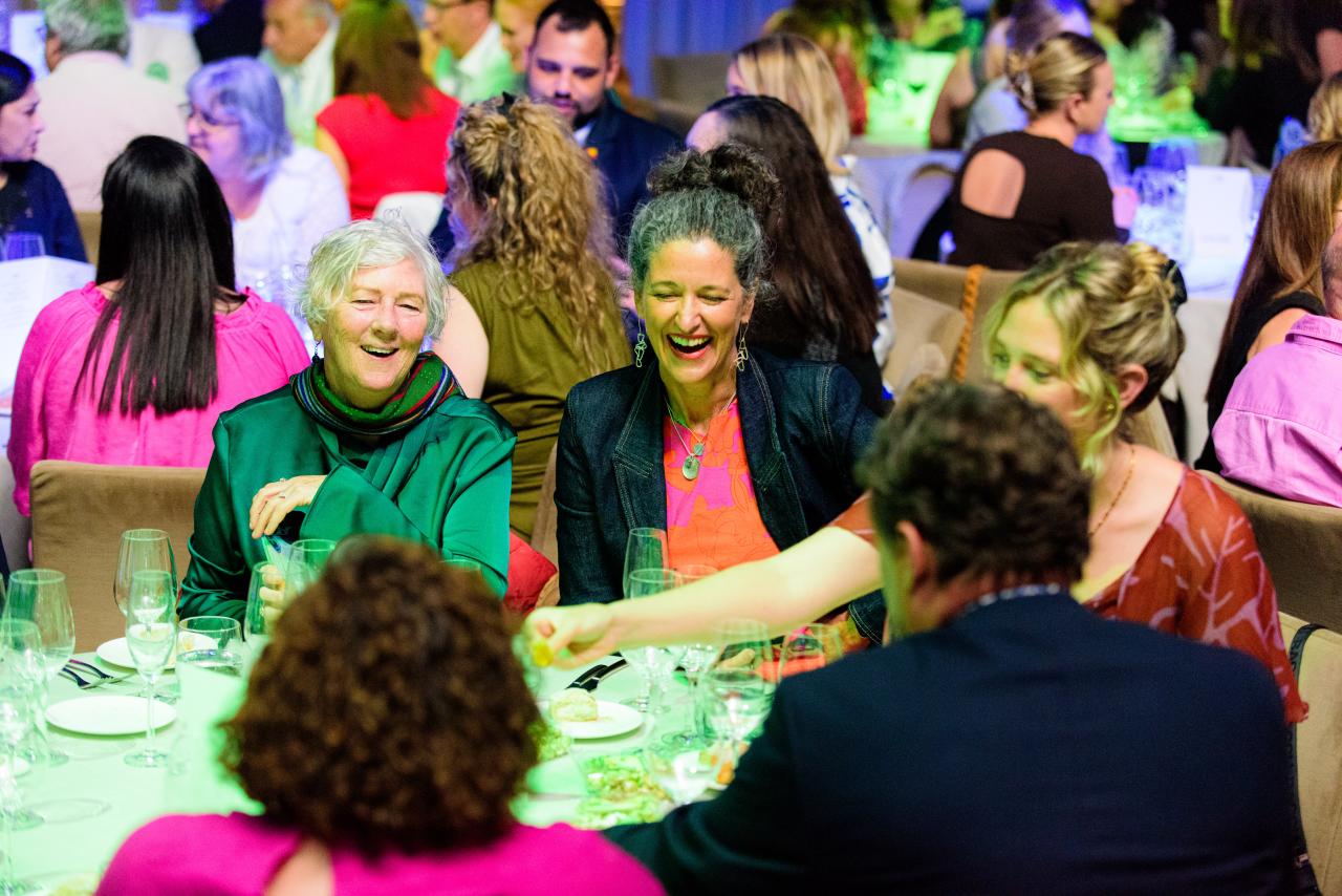 People laughing at corporate dinner event