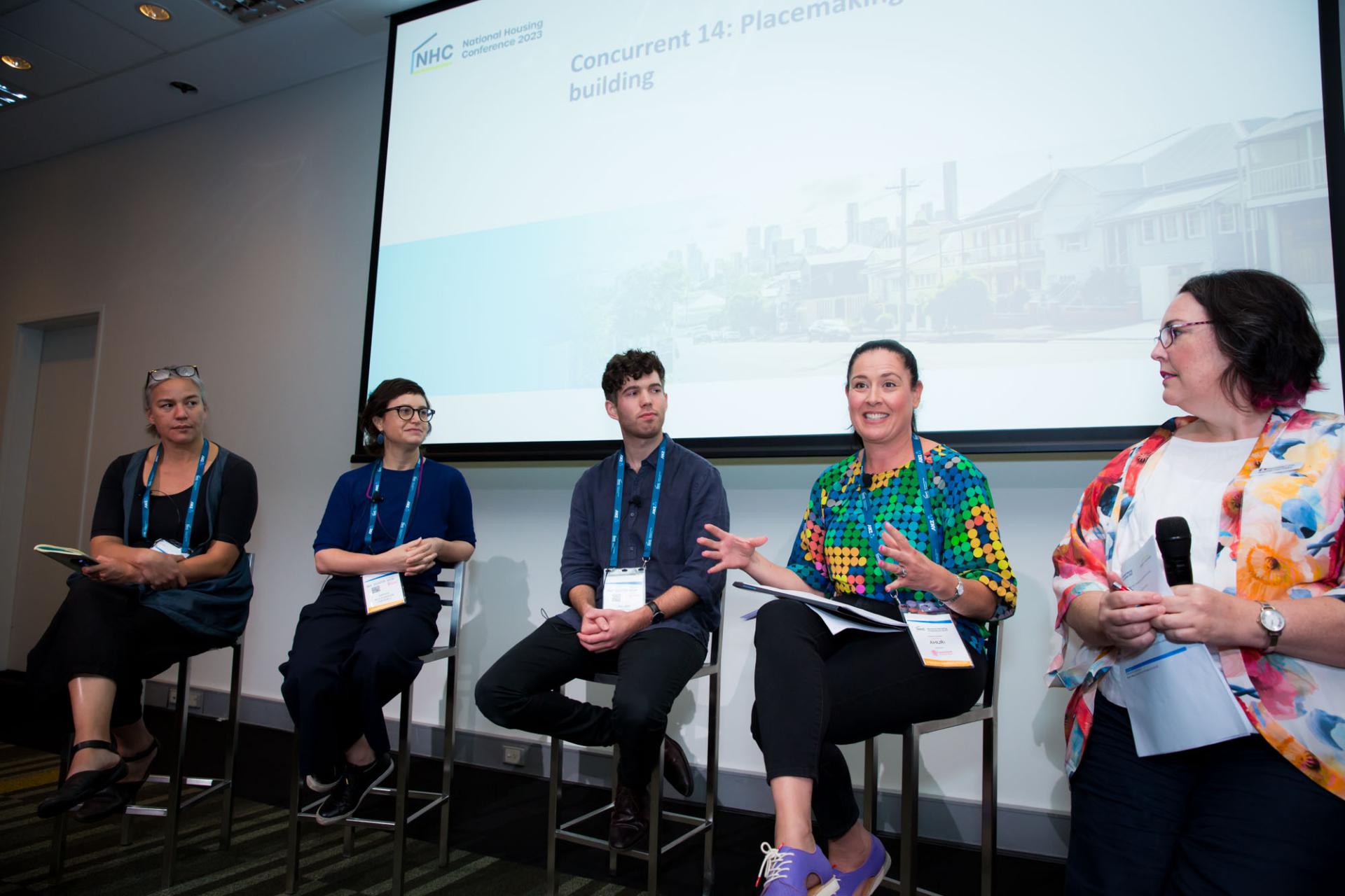 People on a stage engaged in a conference panel discussion